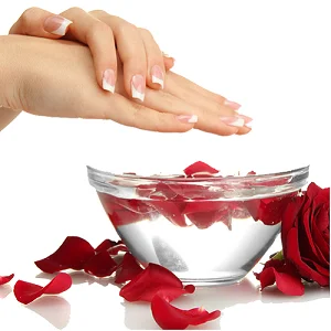 Soft pink manicured nails resting beside a flower