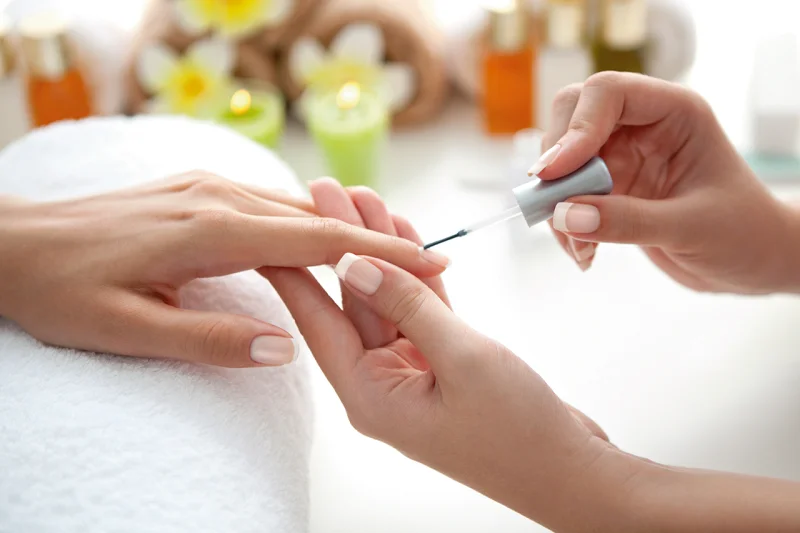 Technician shaping a guest's nails at the manicure table
