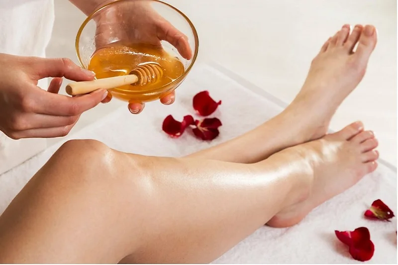 Spa pedicure with warm oil and flower petals